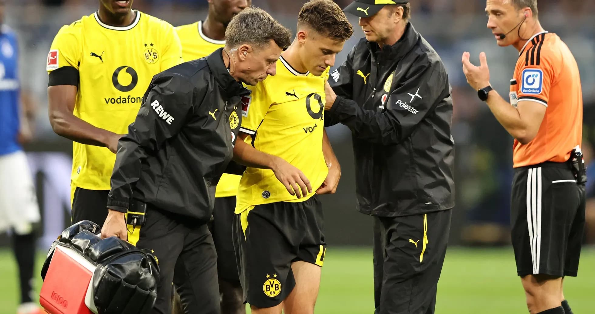 Jugadores de Borussia Dortmund atendiendo a un compañero lesionado