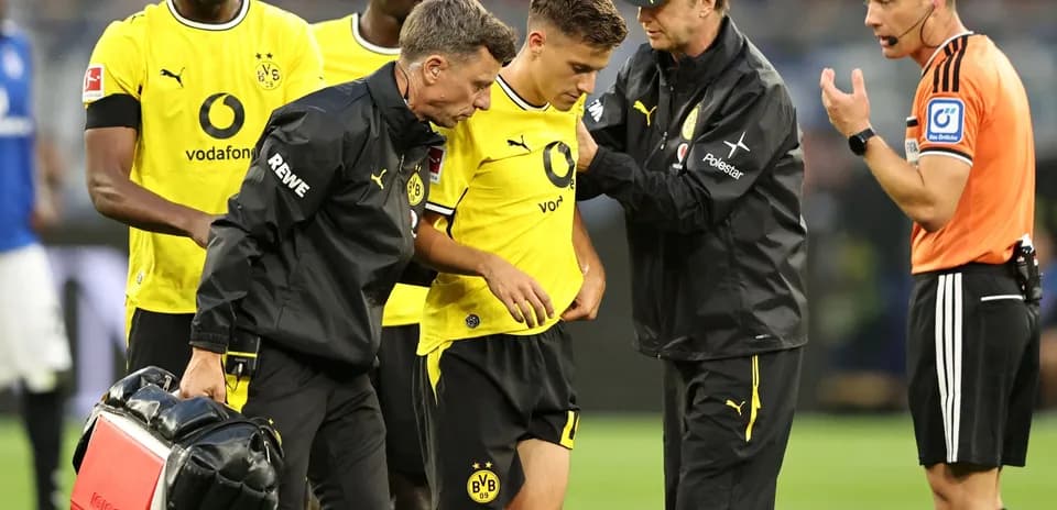 Jugadores de Borussia Dortmund atendiendo a un compañero lesionado