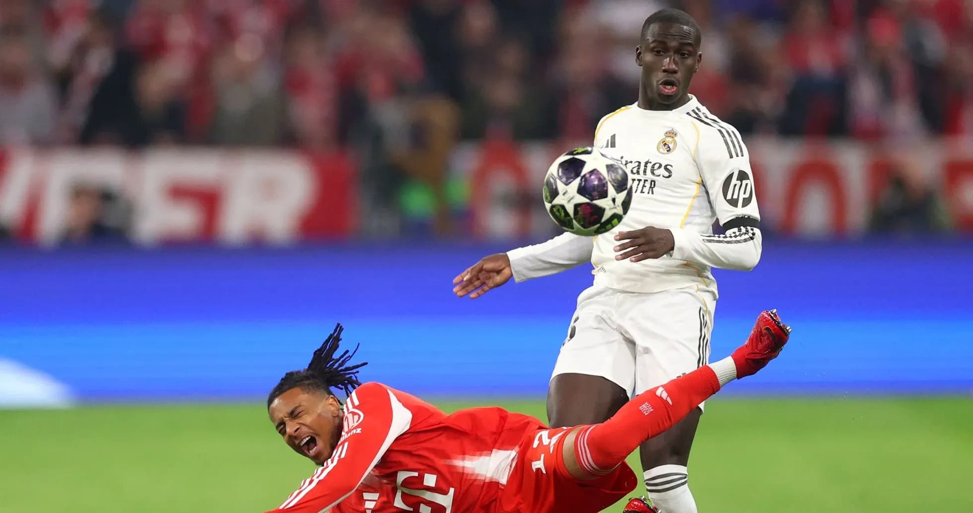 Jugador de Real Madrid driblando mientras rival cae