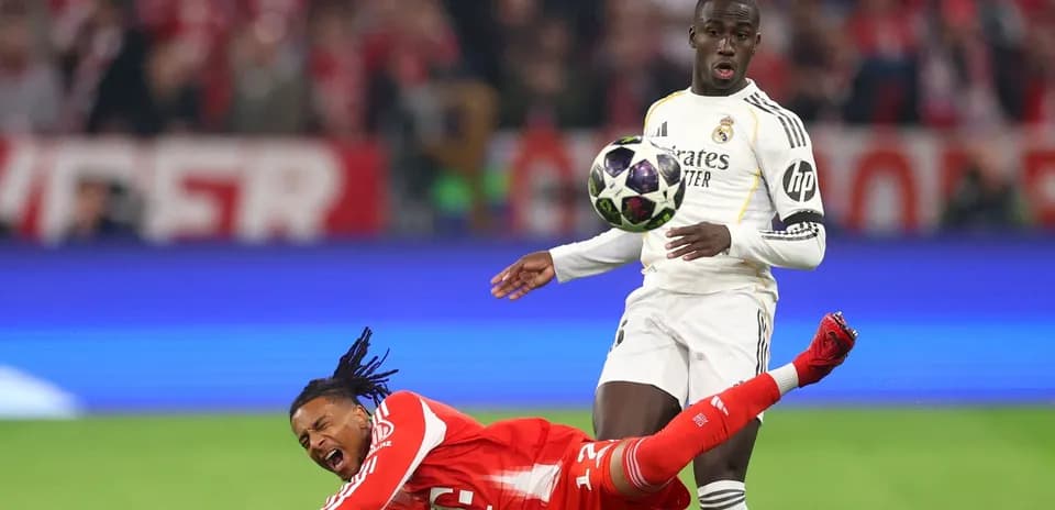 Jugador de Real Madrid driblando mientras rival cae