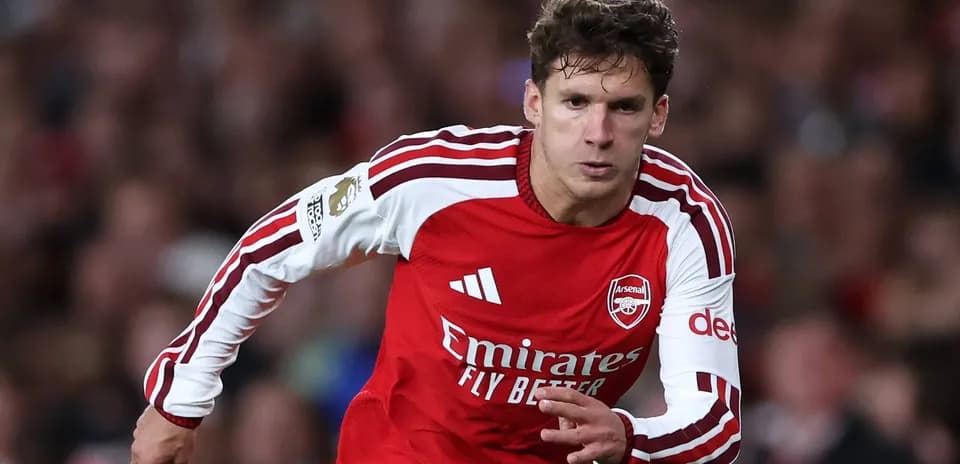 Jugador de Arsenal corriendo con el balón en el campo
