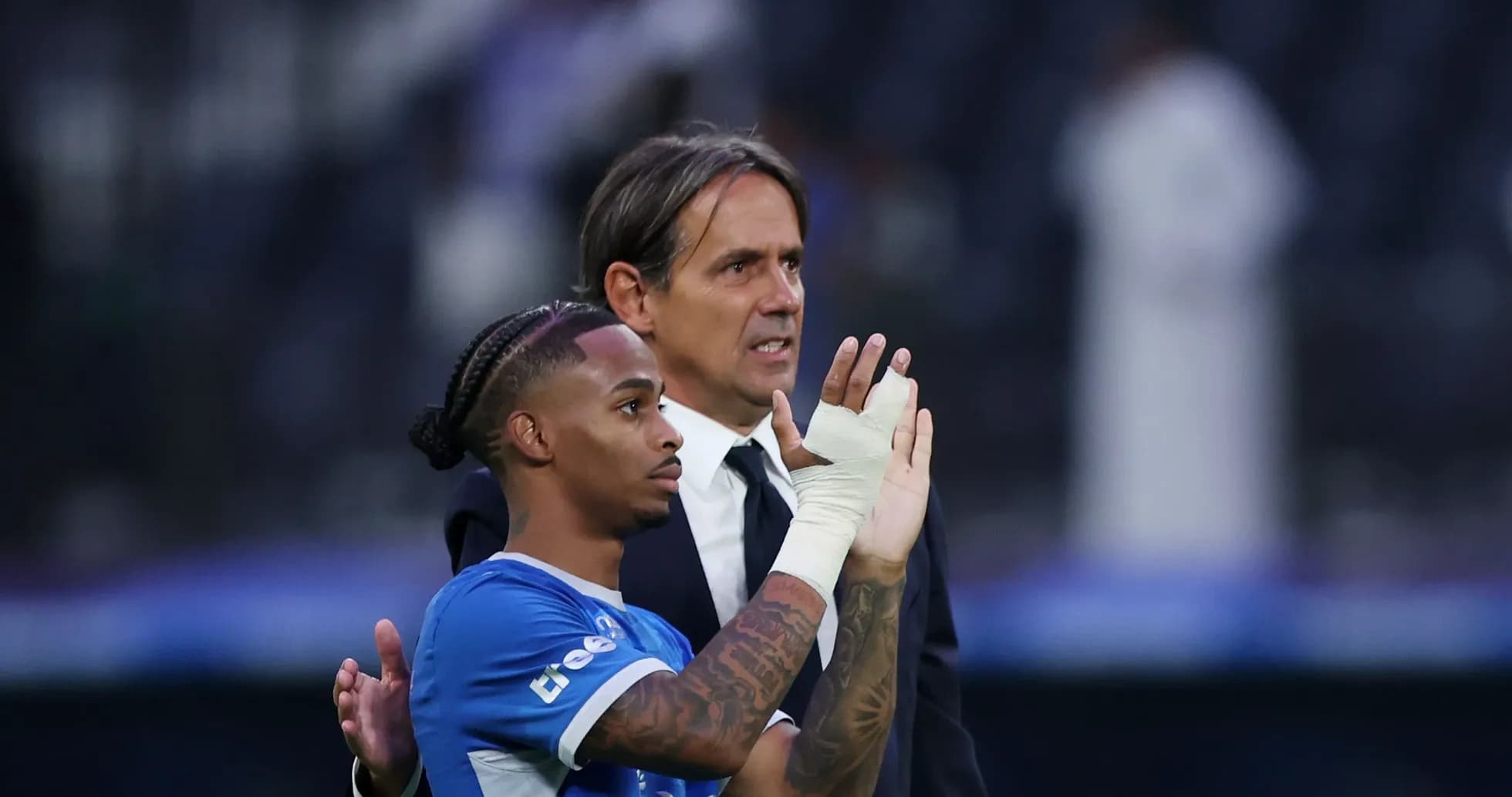 Jugador y entrenador saludando al público tras partido