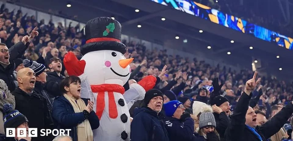 Espectadores animando con muñeco de nieve inflable