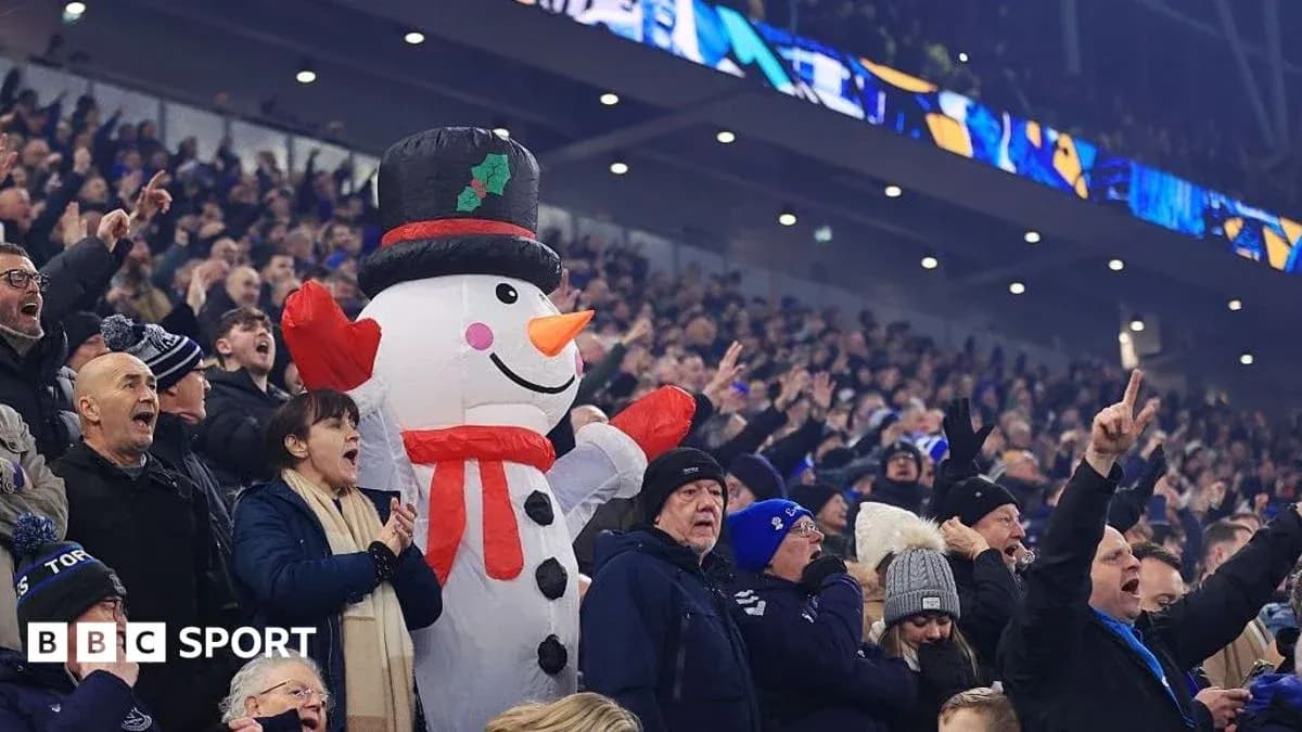 Espectadores animando con muñeco de nieve inflable