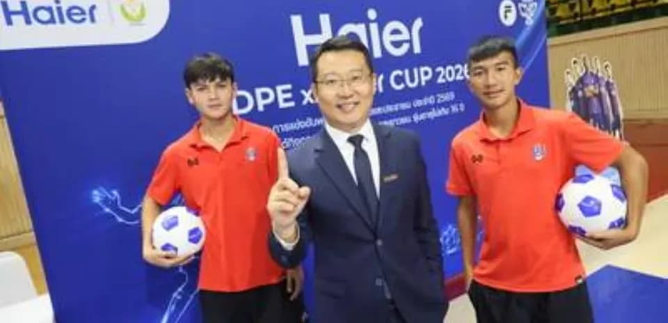 Tres personas posando en evento de fútbol con balón