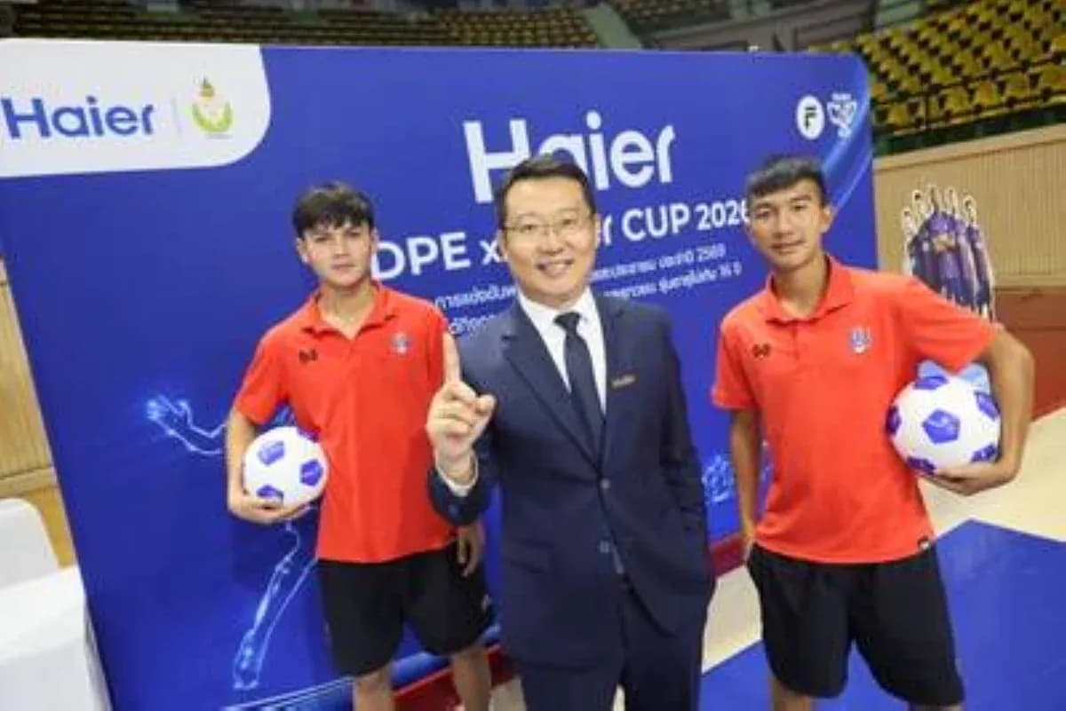 Tres personas posando en evento de fútbol con balón