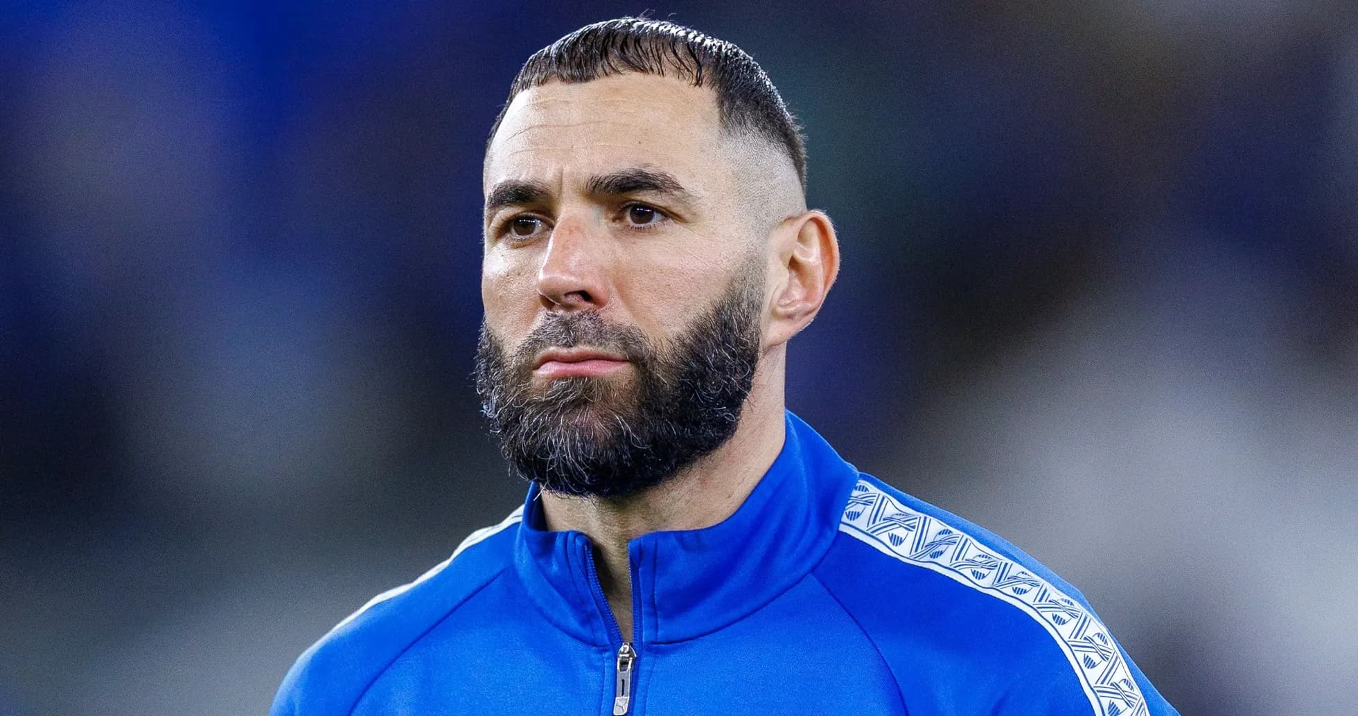 Jugador con barba en uniforme azul mirando hacia adelante