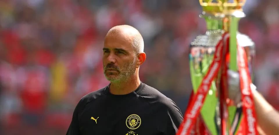 Entrenador de Manchester City junto a trofeo de campeonato
