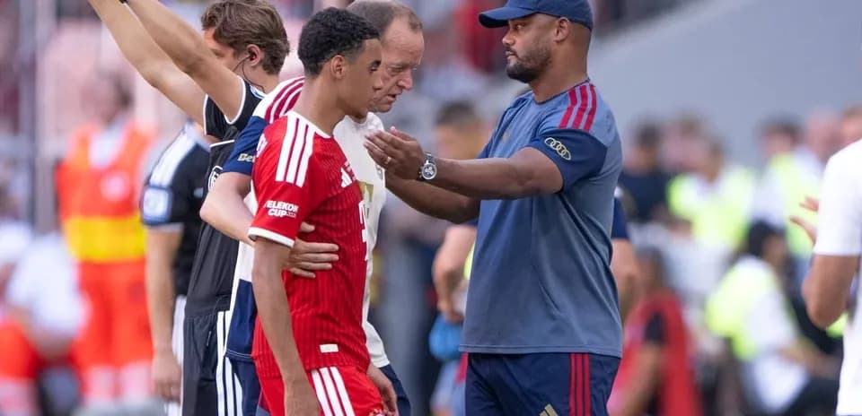 Entrenador hablando con jugador en el banquillo