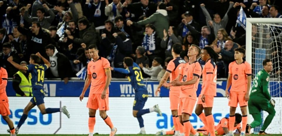 Jugadores de equipo en camiseta rosa tras un gol rival