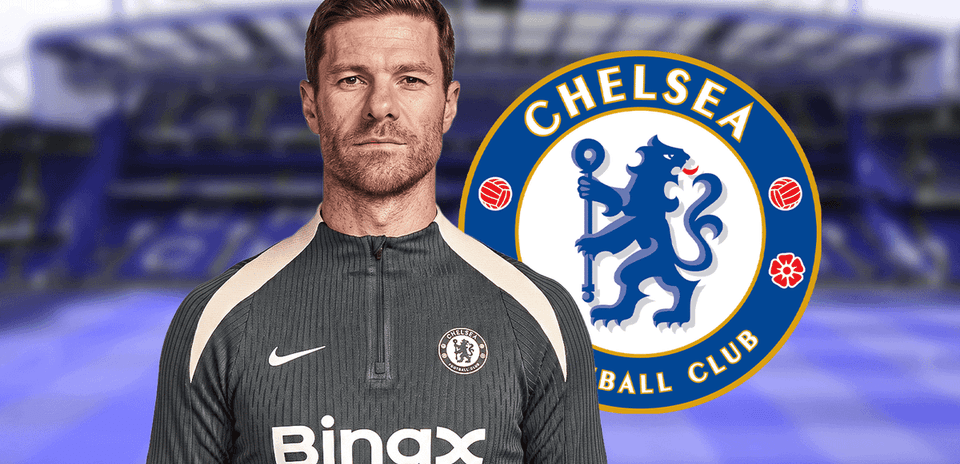 Entrenador posando frente al logo del Chelsea