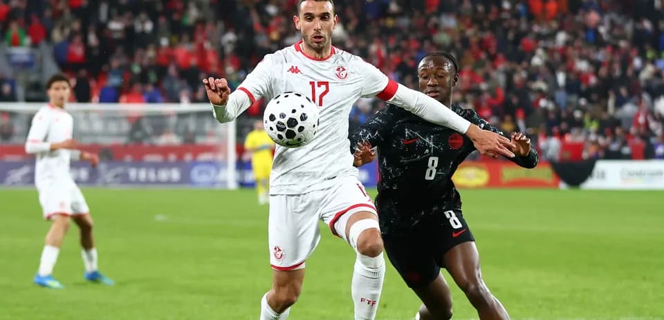 Jugador tunecino controla el balón en partido de fútbol