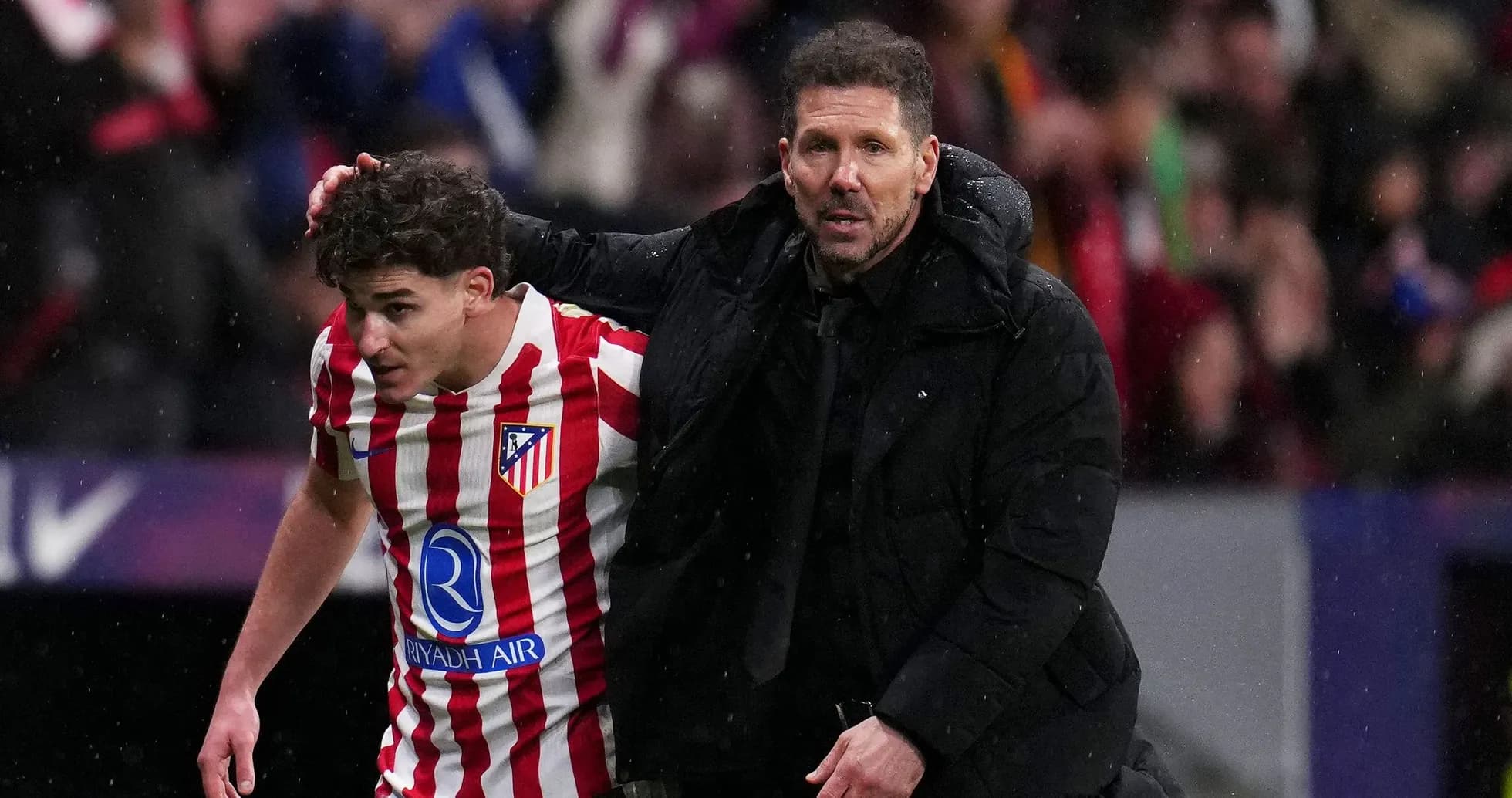 Entrenador apoyando a jugador de Atlético de Madrid