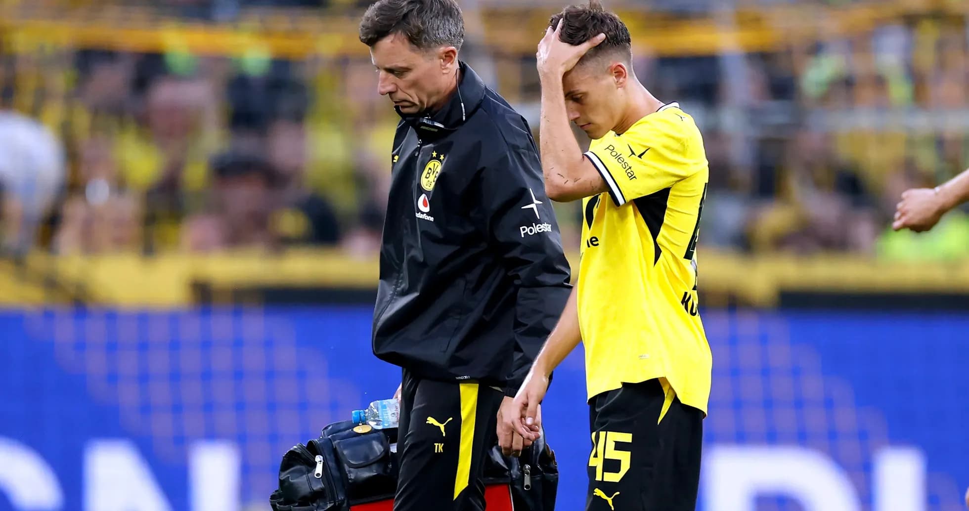 Jugador de Borussia Dortmund caminando con el médico