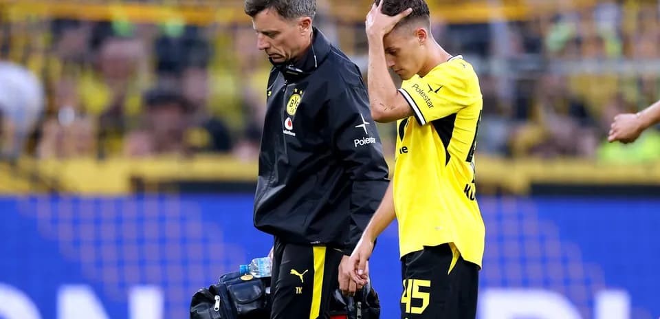 Jugador de Borussia Dortmund caminando con el médico