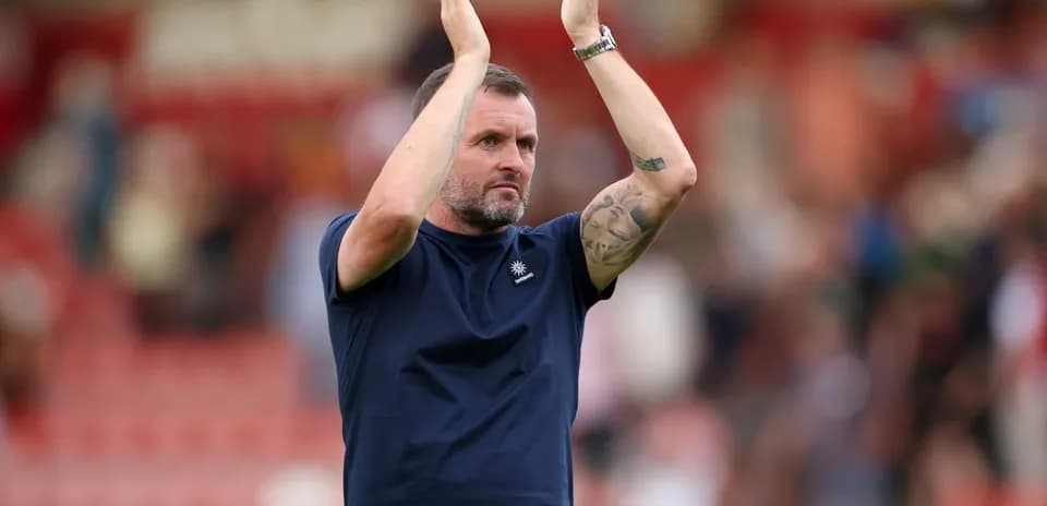 Entrenador aplaudiendo a la afición tras el partido