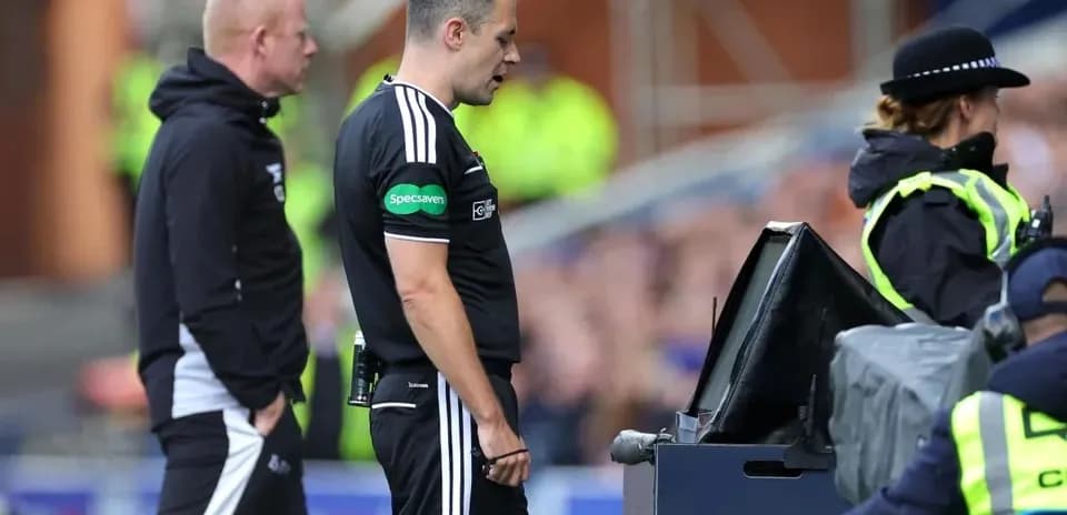 Árbitro revisando jugada en monitor VAR durante partido