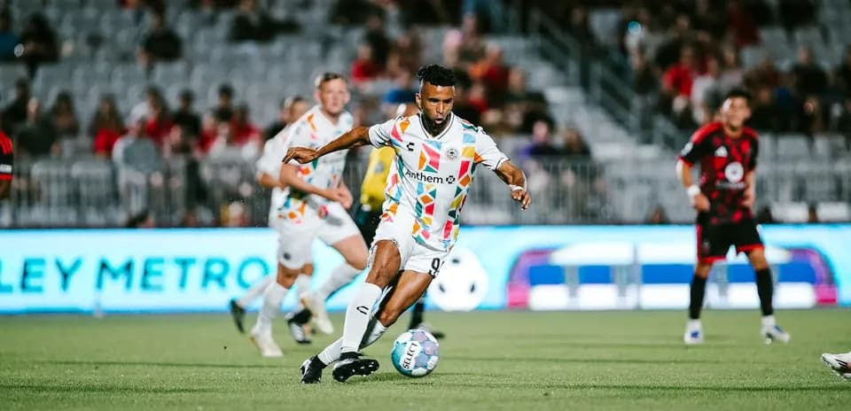 Jugador driblando en partido de fútbol