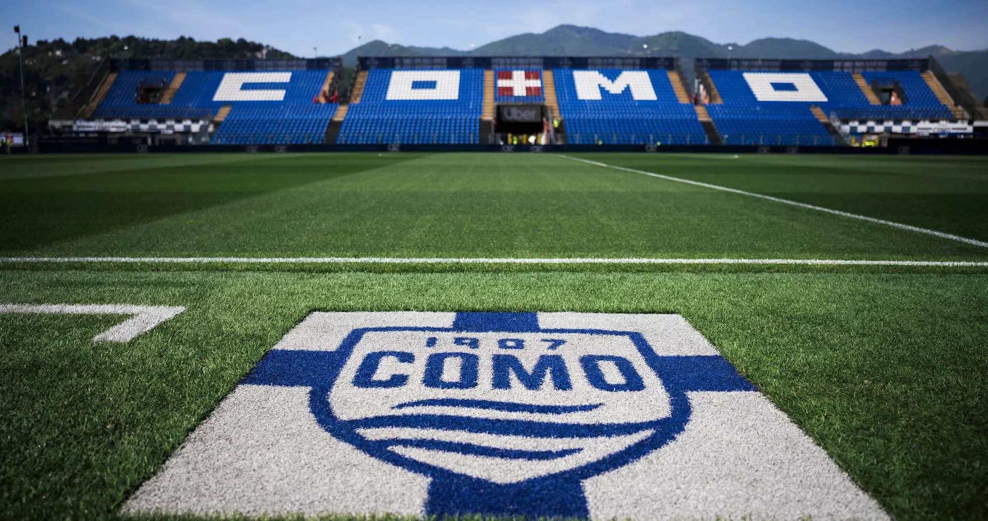 Campo de fútbol con logo del FC Como en primer plano