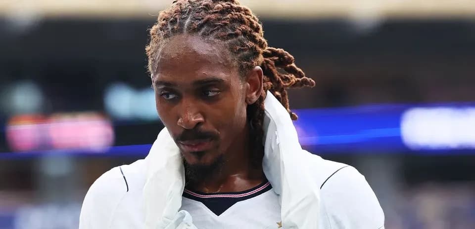 Jugador con cabello trenzado saliendo del campo