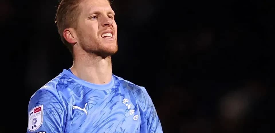 Portero con camiseta azul en el campo de juego