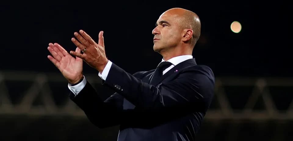 Entrenador aplaudiendo en el banquillo durante el partido