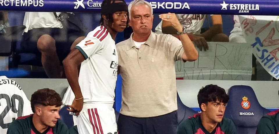 Entrenador hablando con jugador en banquillo
