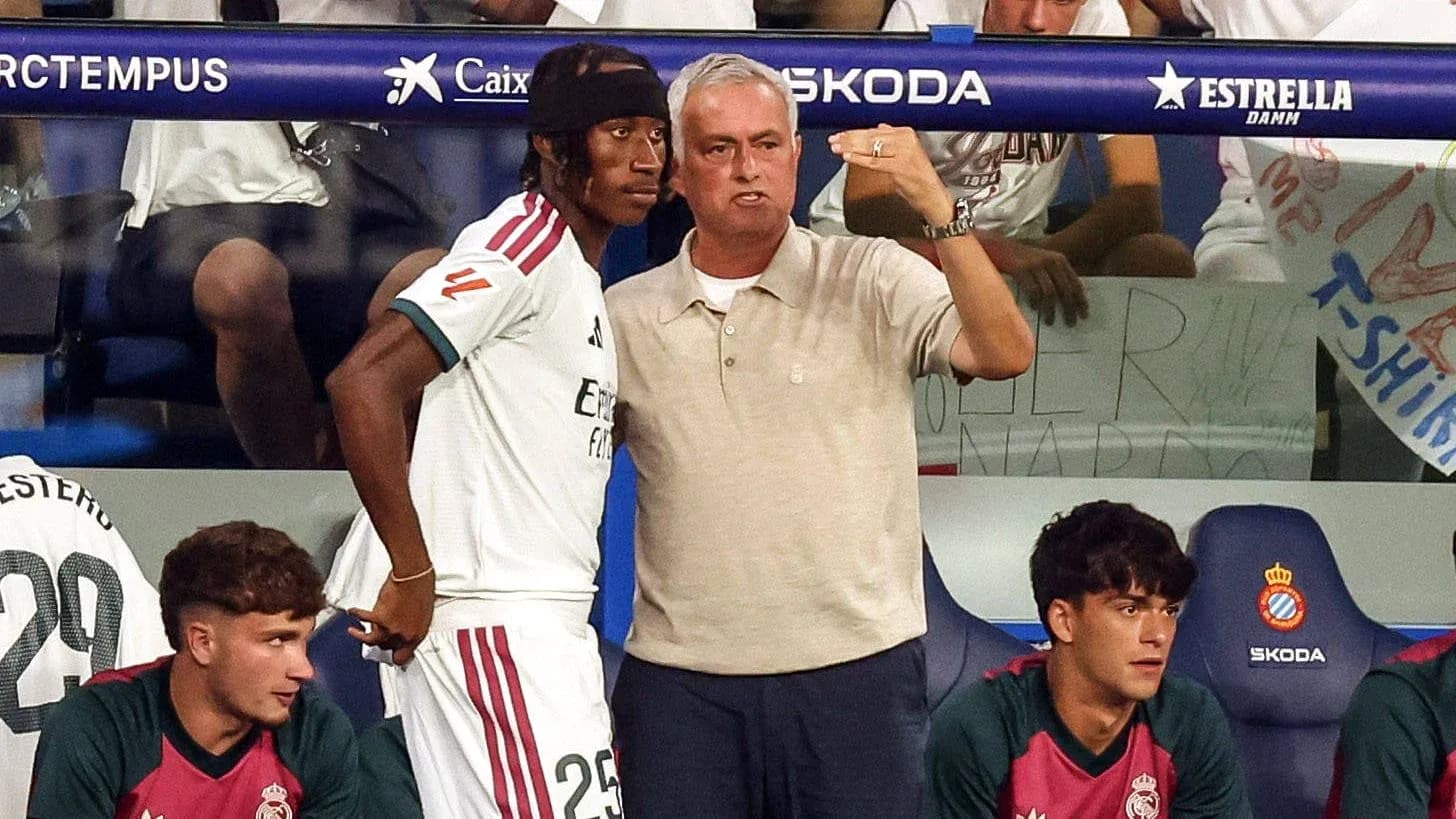 Entrenador hablando con jugador en banquillo