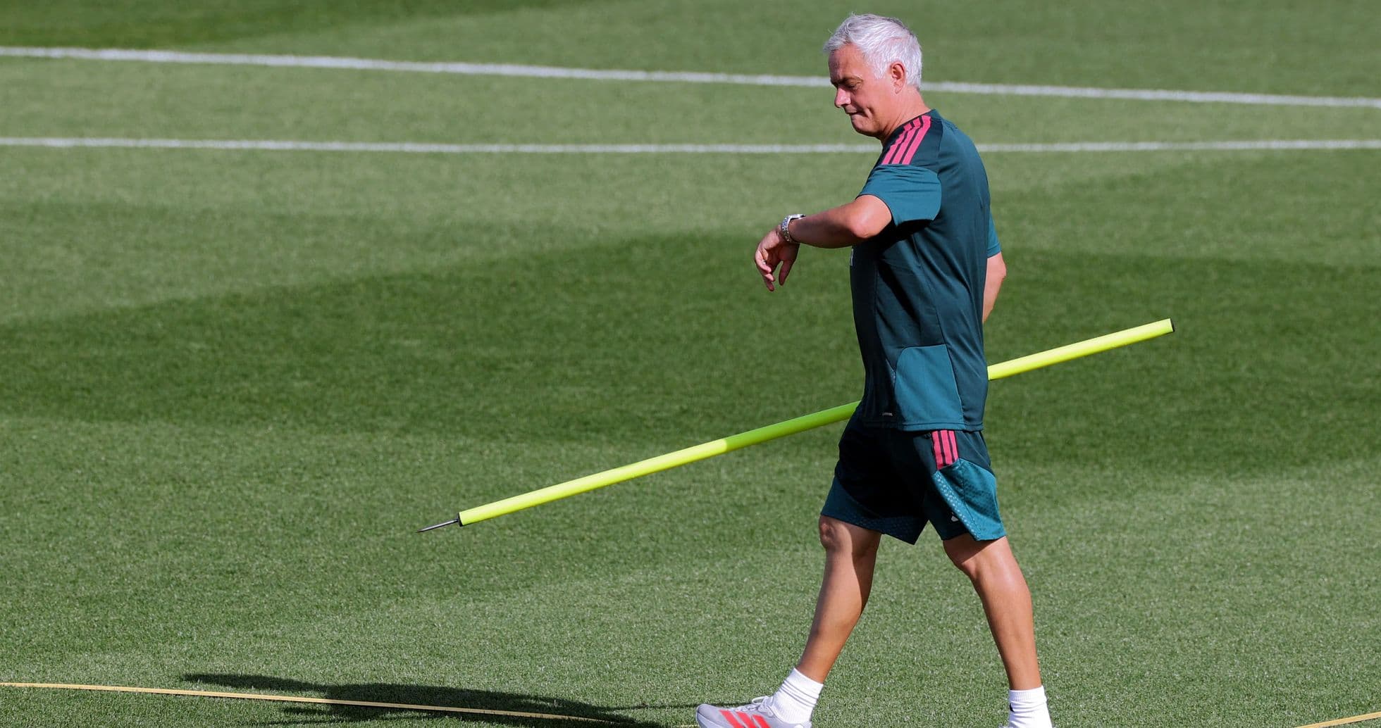 Entrenador caminando con una vara de entrenamiento