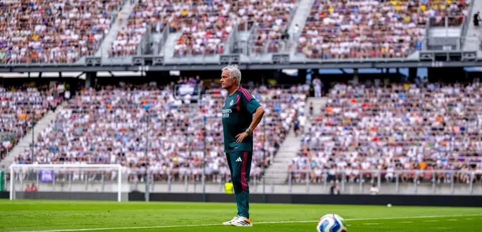 Entrenador de pie en la línea de banda durante el partido