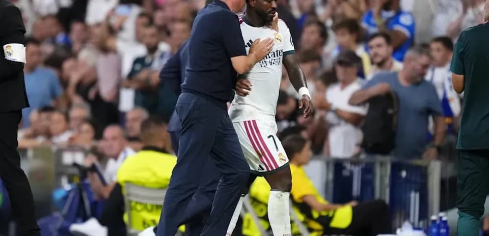Entrenador abrazando a jugador de Real Madrid en el campo