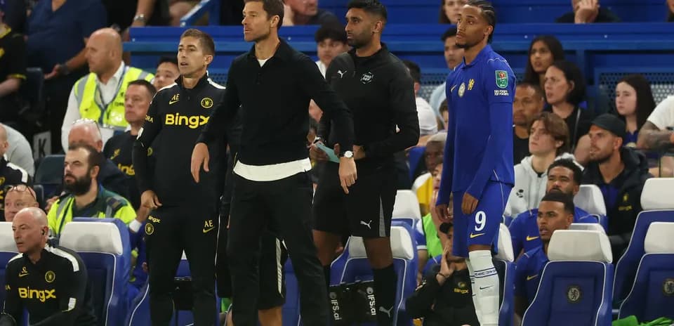 Entrenadores y jugador esperando en la banca