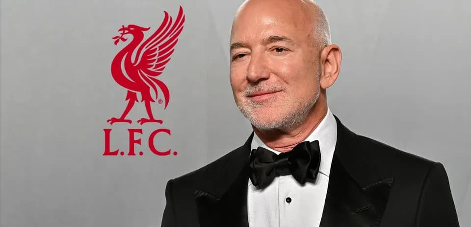 Hombre vestido de gala junto al logo de Liverpool