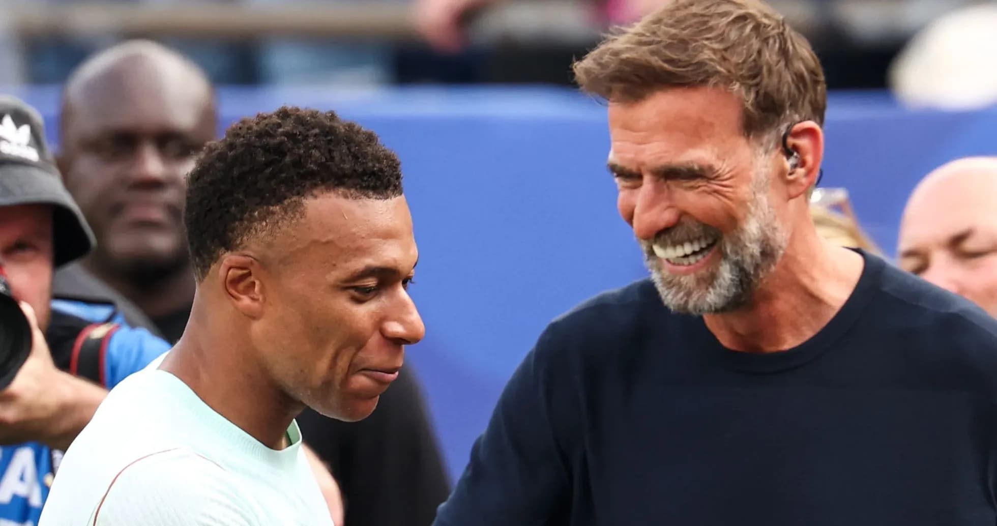 Kylian Mbappé y entrenador sonriendo en el evento