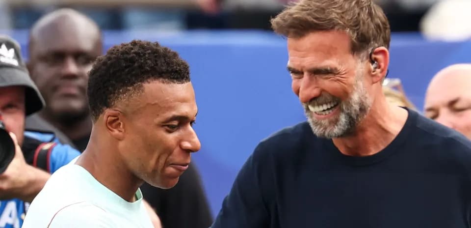 Kylian Mbappé y entrenador sonriendo en el evento