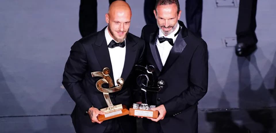 Dos personas sosteniendo premios en una ceremonia