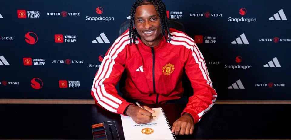 Jugador de Manchester United firmando contrato en mesa
