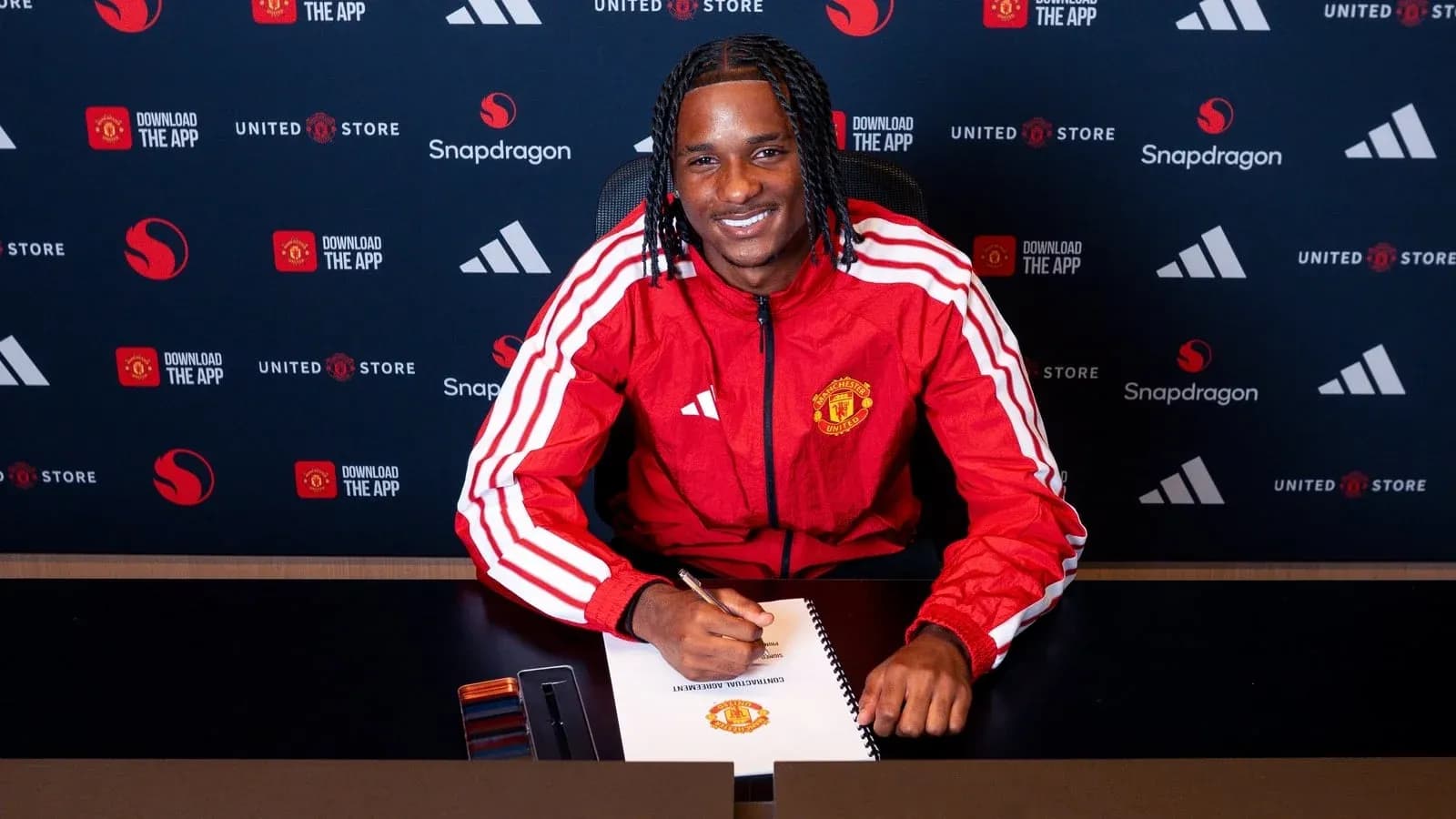 Jugador de Manchester United firmando contrato en mesa