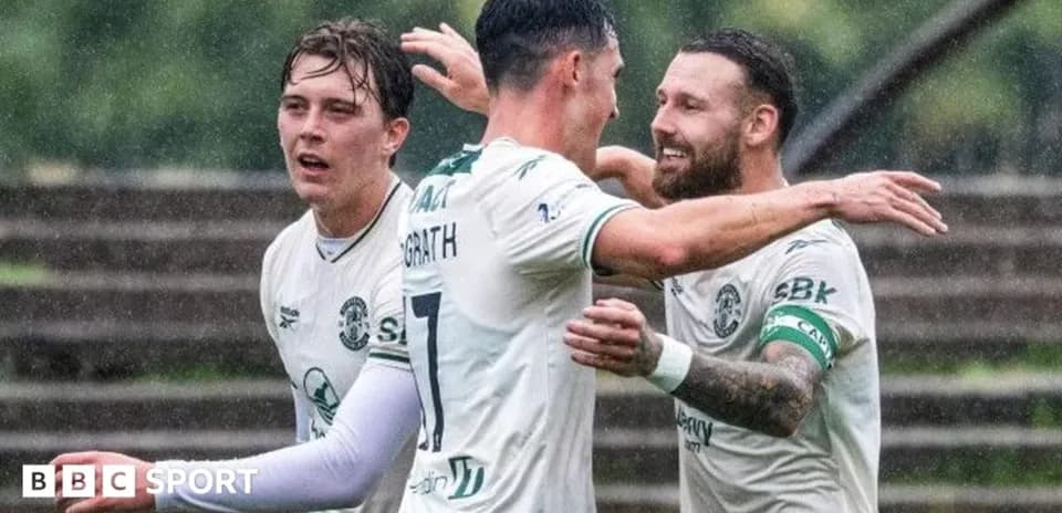 Jugadores de Hibernian celebrando un gol bajo la lluvia