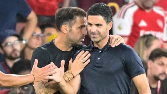 Dos entrenadores conversando durante el partido