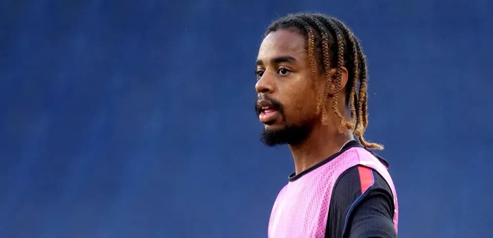 Jugador entrenando con pechera rosa en el campo