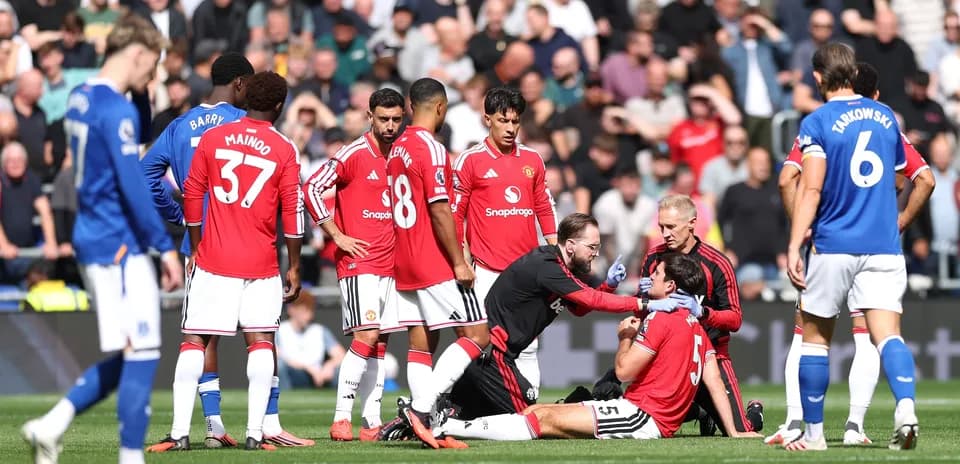 Jugadores de Manchester United atienden a compañero lesionado