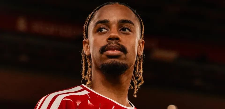 Jugador en camiseta roja mirando hacia el horizonte