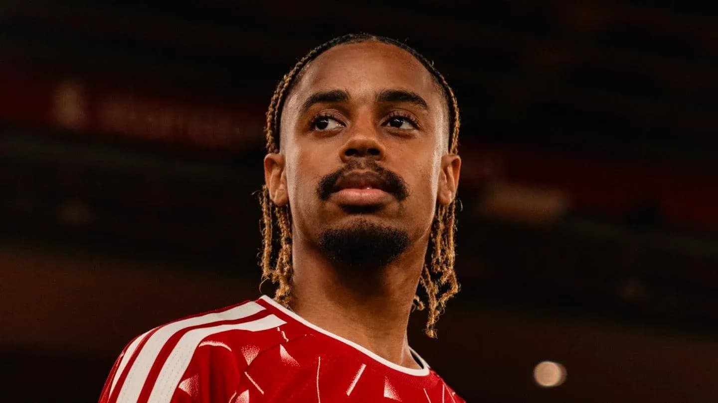 Jugador en camiseta roja mirando hacia el horizonte