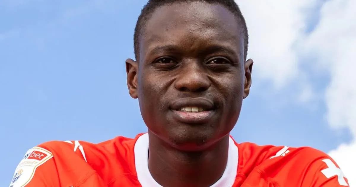 Jugador sonriendo con camiseta roja frente a cielo azul