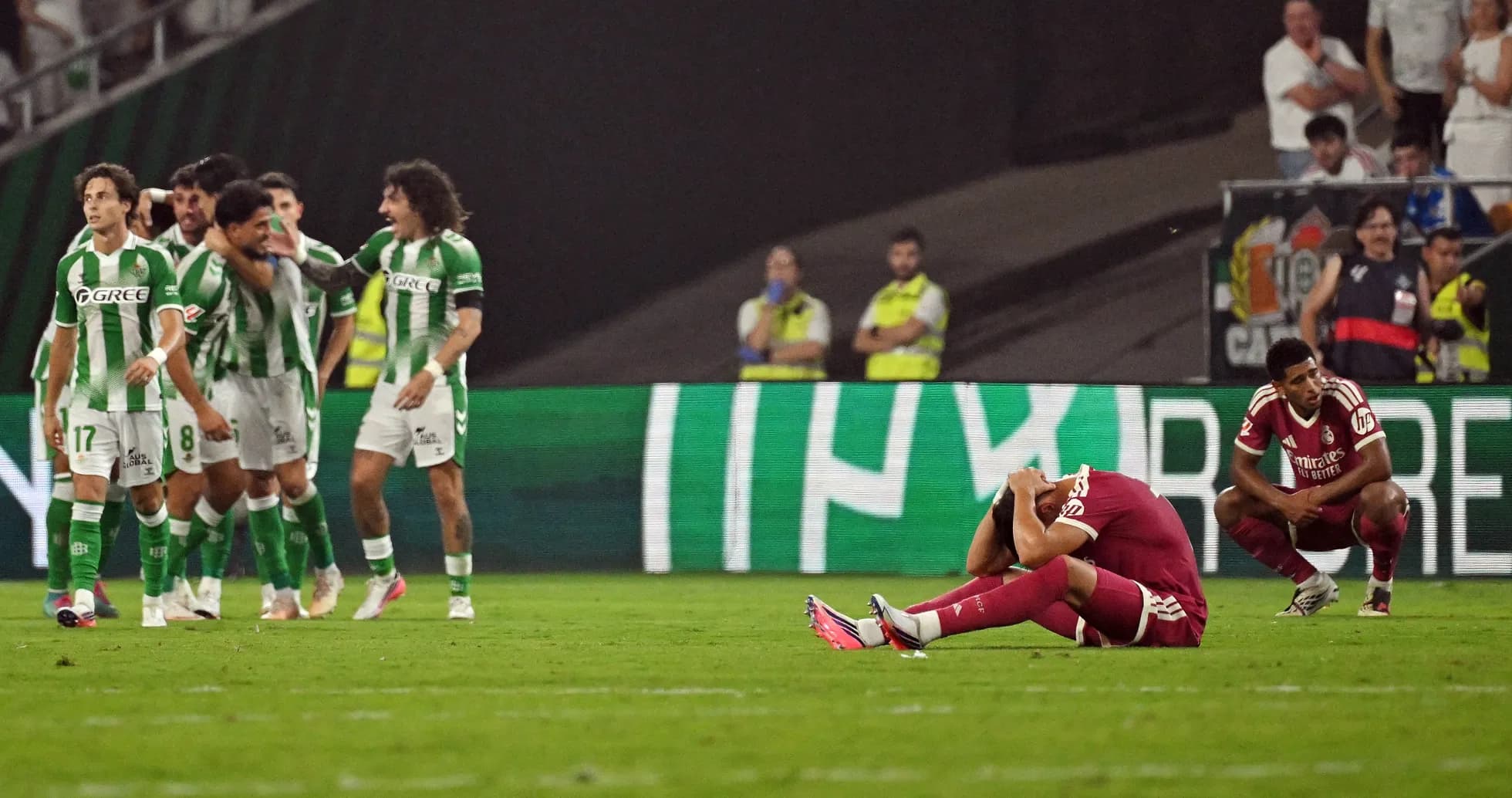 Jugadores de Betis celebrando, mientras adversario se lamenta
