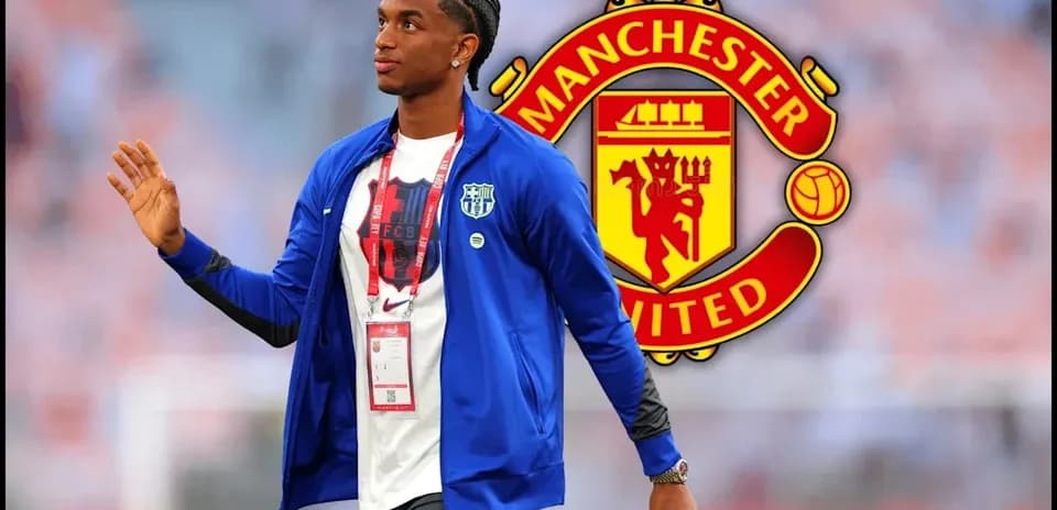 Jugador caminando con chaqueta azul y logo de Manchester United