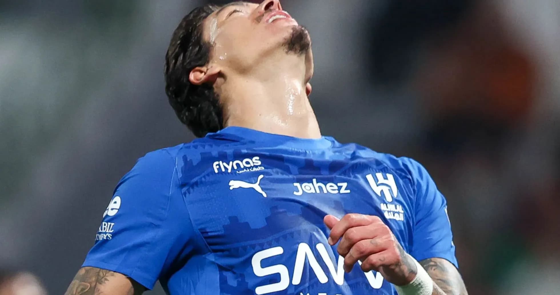 Jugador de fútbol en camiseta azul con expresión de frustración
