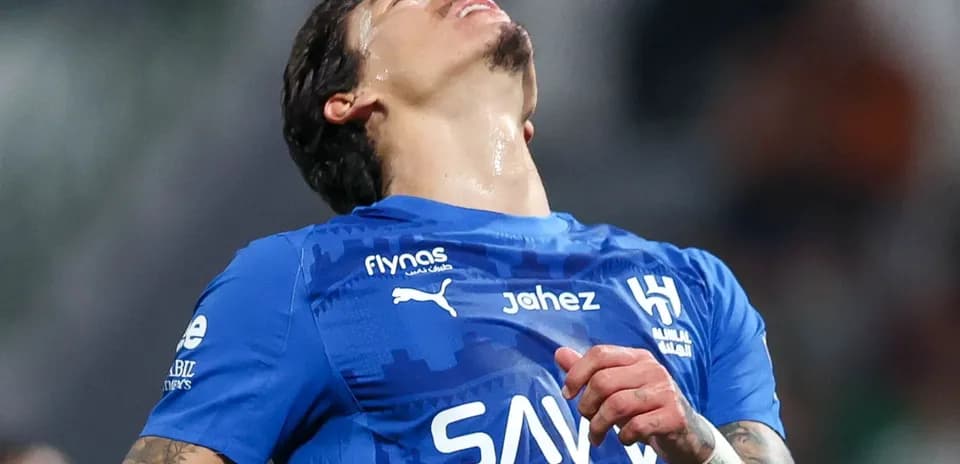 Jugador de fútbol en camiseta azul con expresión de frustración