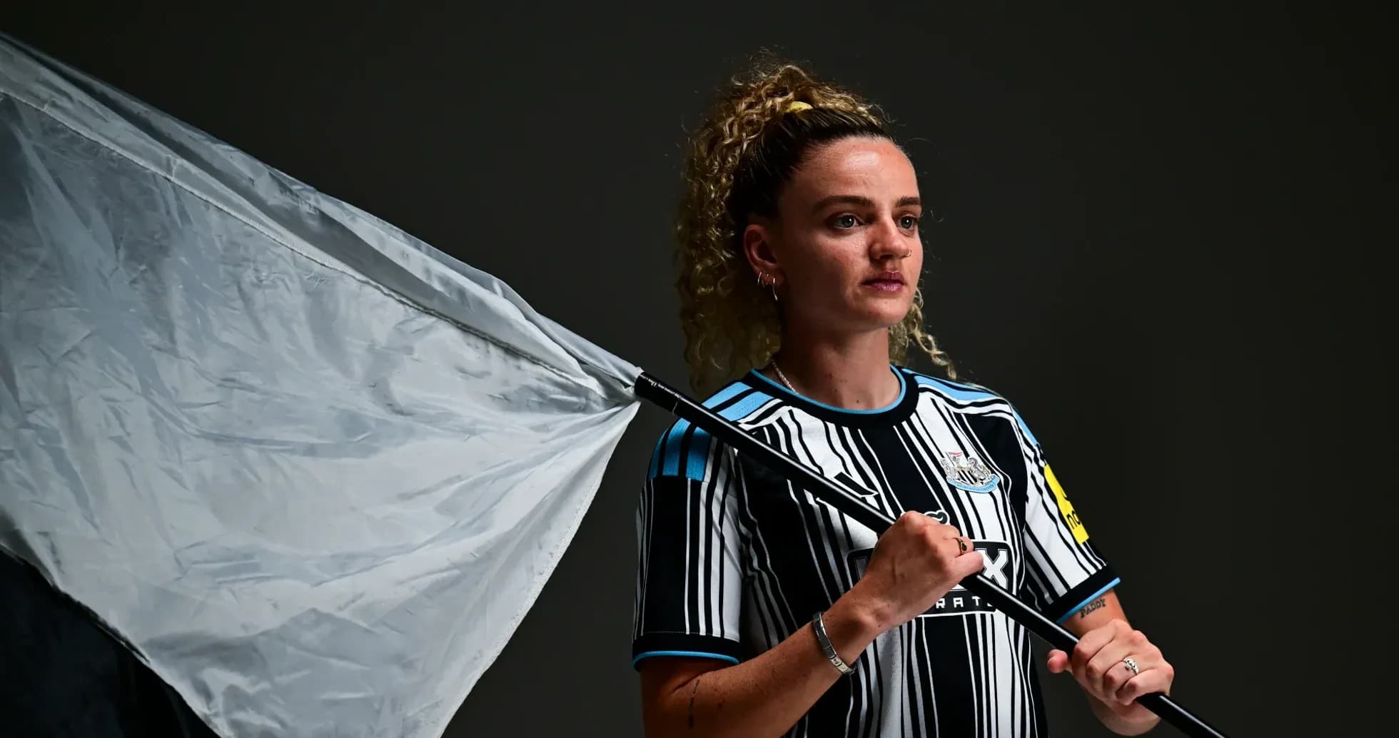 Jugadora de Newcastle sosteniendo una bandera en estudio